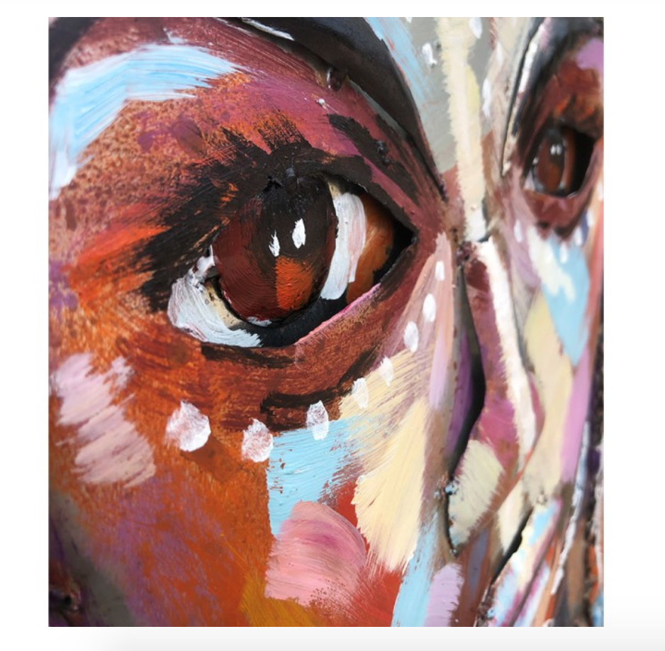 Close-up of a colorful painting of a face with a prominent eye.