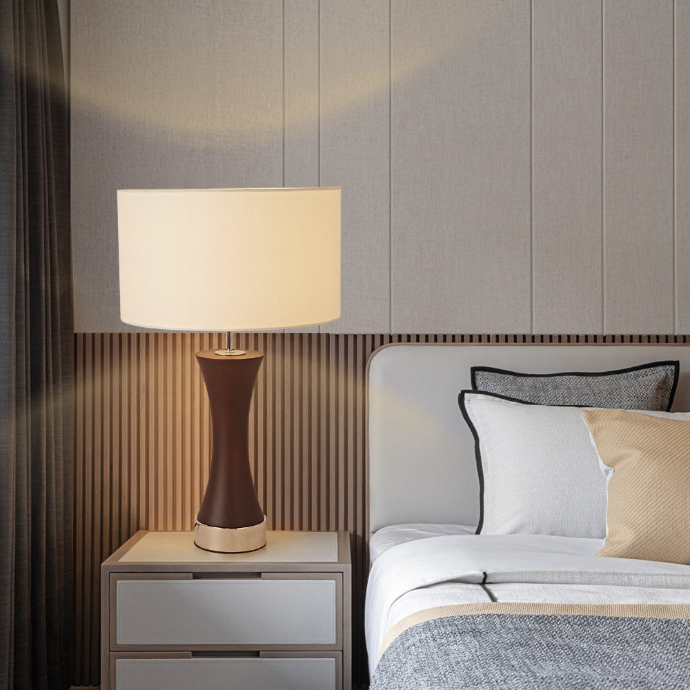 Bedroom with a lamp on a nightstand next to a bed with pillows.