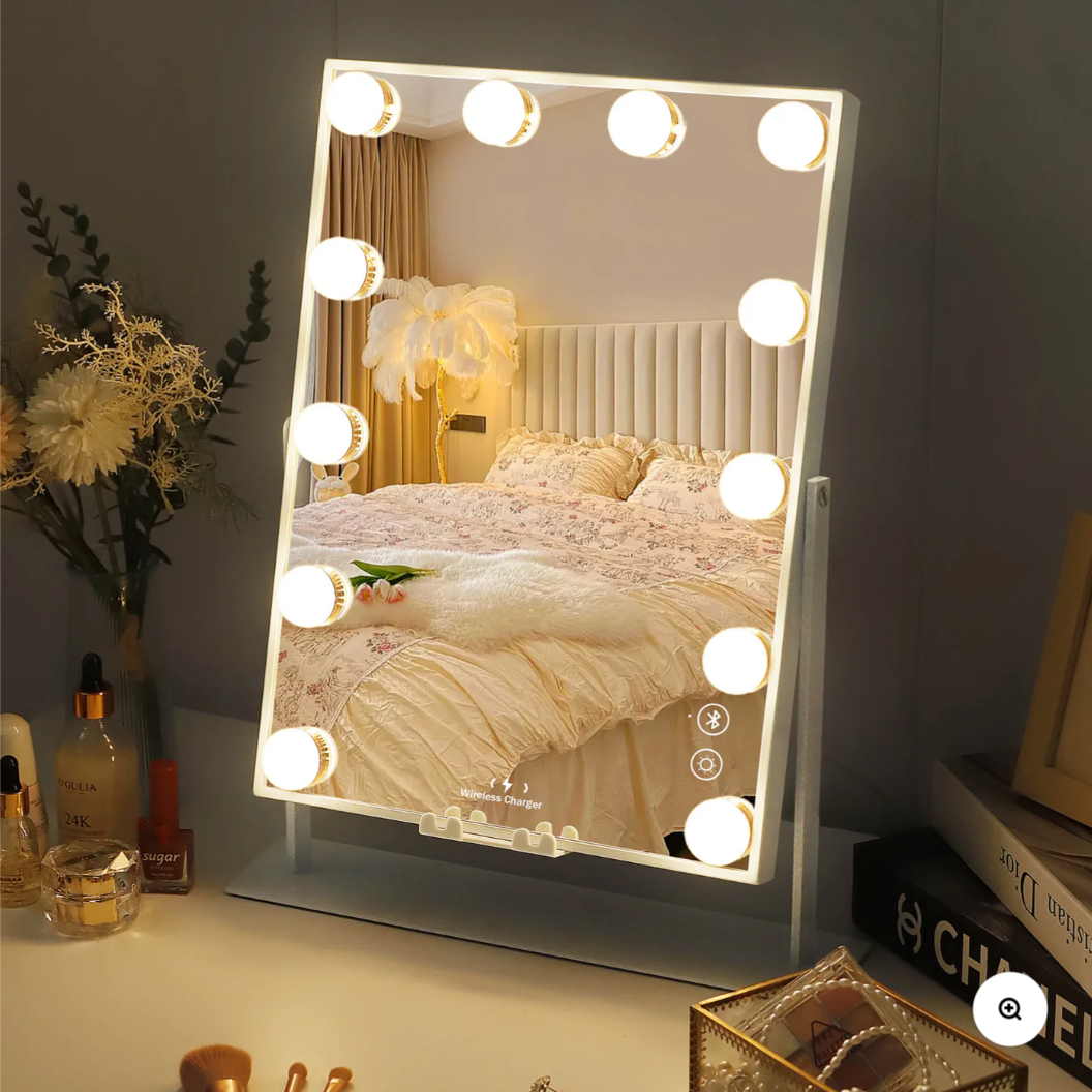 Lighted vanity mirror on a desk with decorative items in a bedroom setting