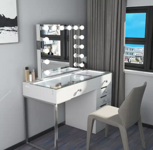 White vanity table with mirror and lights in a room with a window and curtains.
