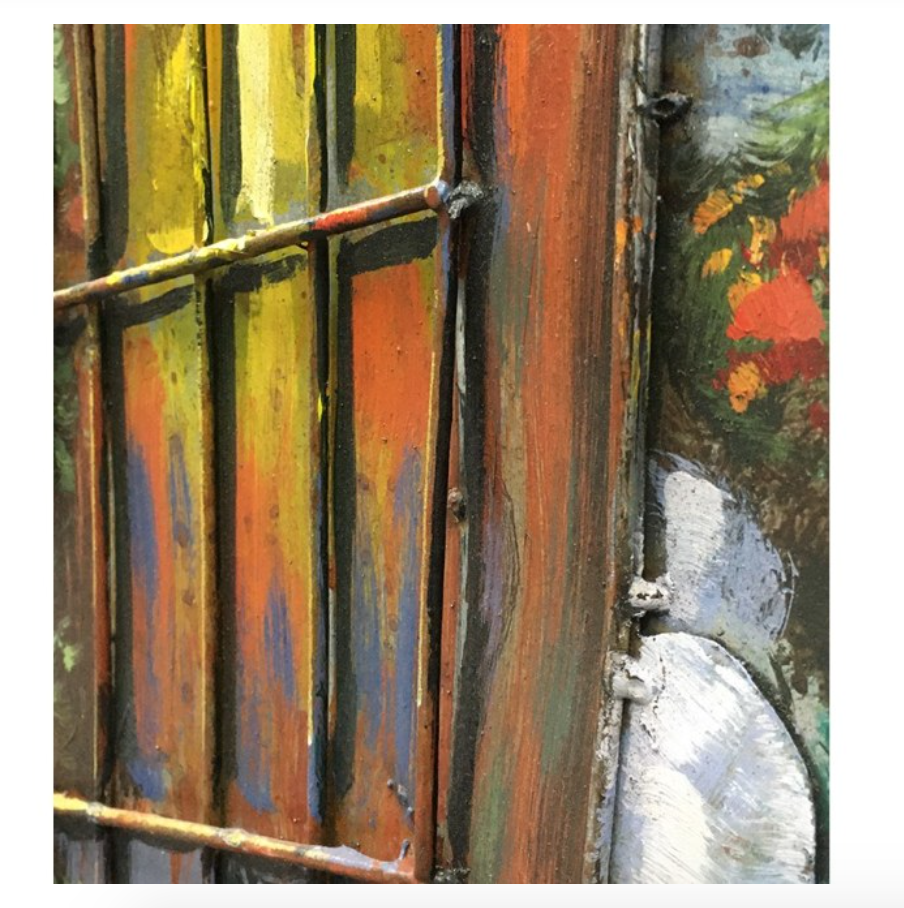 Close-up of a colorful metal gate with floral painting in the background
