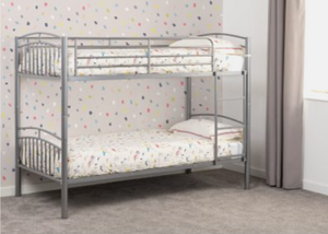Bunk bed with white bedding in a room with polka dot wallpaper