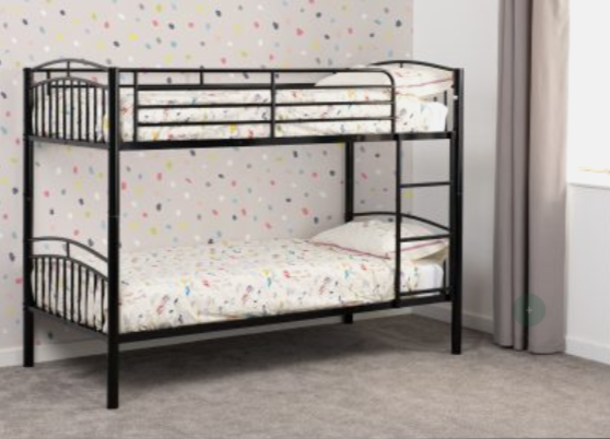 Black metal bunk bed in a room with colorful polka dot wallpaper.