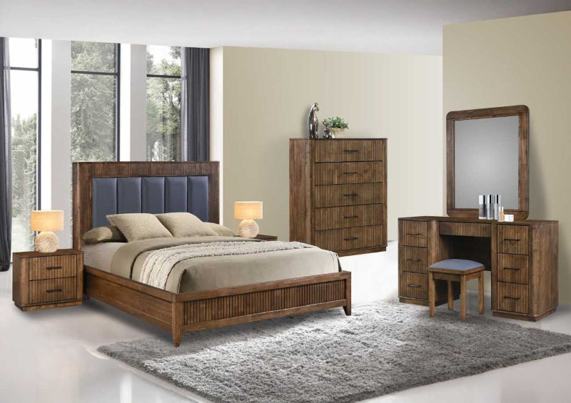 Wooden bedroom furniture set with bed, dresser, and desk in a room with large windows.