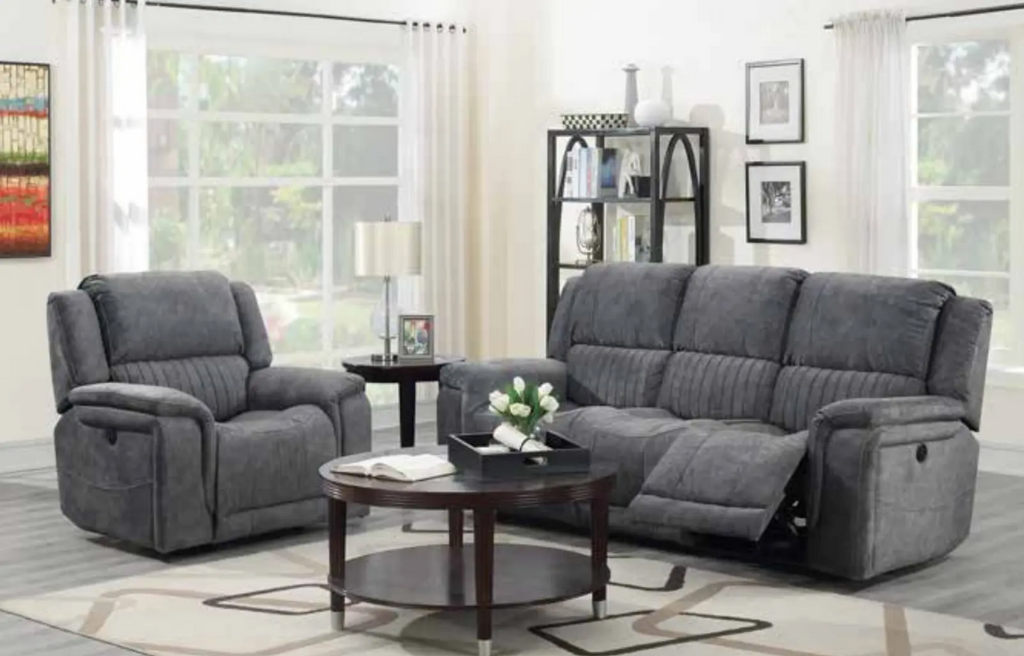 Gray reclining sofa set in a living room with a coffee table and decor items.