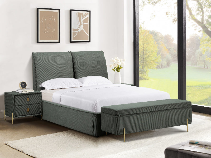 Green upholstered bed with matching bench in a bright bedroom with large windows.