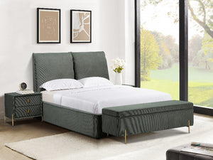 Green upholstered bed with matching bench in a bright bedroom with large windows.