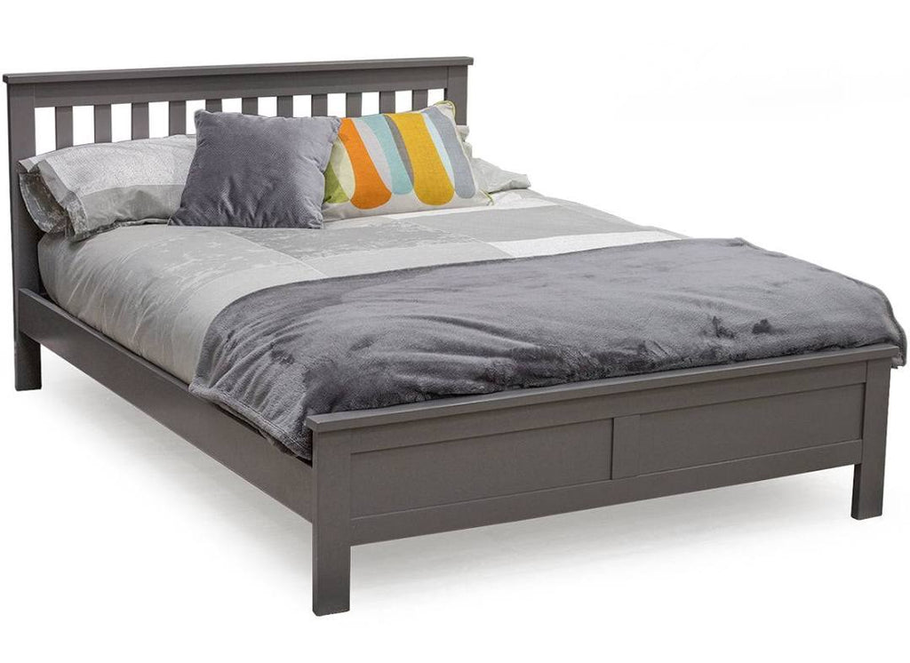 A 4'6ft double bed with gray wooden frame and brown upholstered headboard, adorned with multicolored cushions.