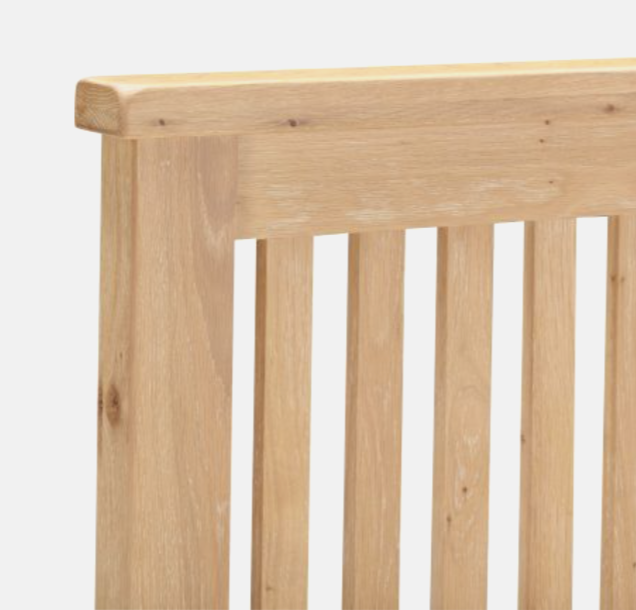 Close-up of a wooden headboard with slatted design on a white background