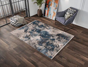 Living room with a patterned rug, chair, and abstract art on a wooden floor.