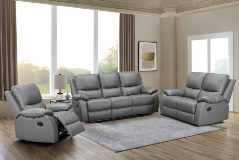Gray reclining sofa set in a living room with large windows and a rug.