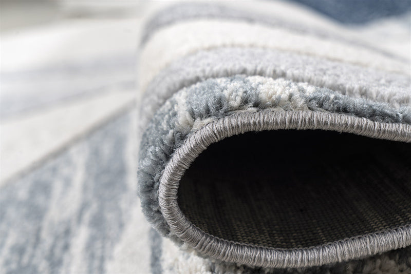Close-up of a textured gray rug with a blurred background