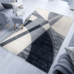 Geometric patterned rug in a living room setting with a gray sofa and coffee table.