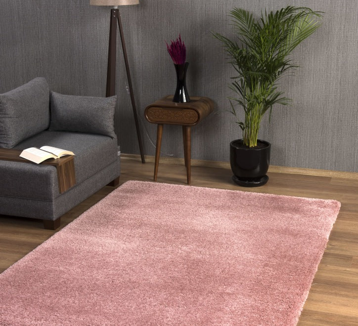 A small rectangular pink rug in a living room setting, with a shaggy texture, complementing the room's decor.